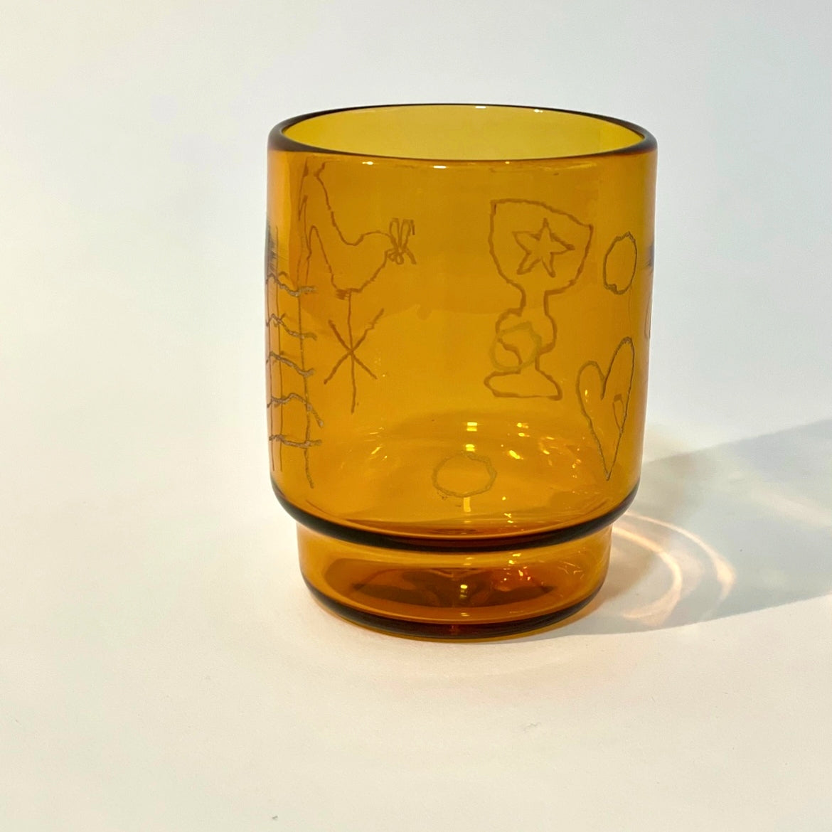 Glass tumbler engraved with motifs of a ladder, weather vane, chalice, and rest